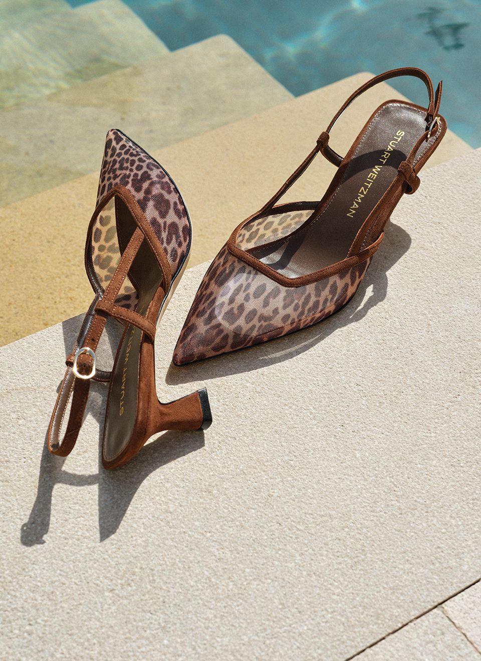 The Stuart Weitzman Vinnie Slingback Pump in Leopard-Print Mesh and Suede, displayed poolside. 